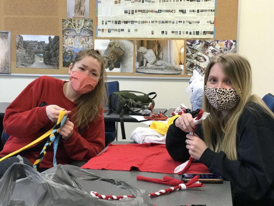 Alexa Shockley (left) and Emily Hollandsworth (right), sisters of local sorority Alpha Beta Chi, make dog toys out of old T-shirts at a school-approved, socially distanced service opportunity.